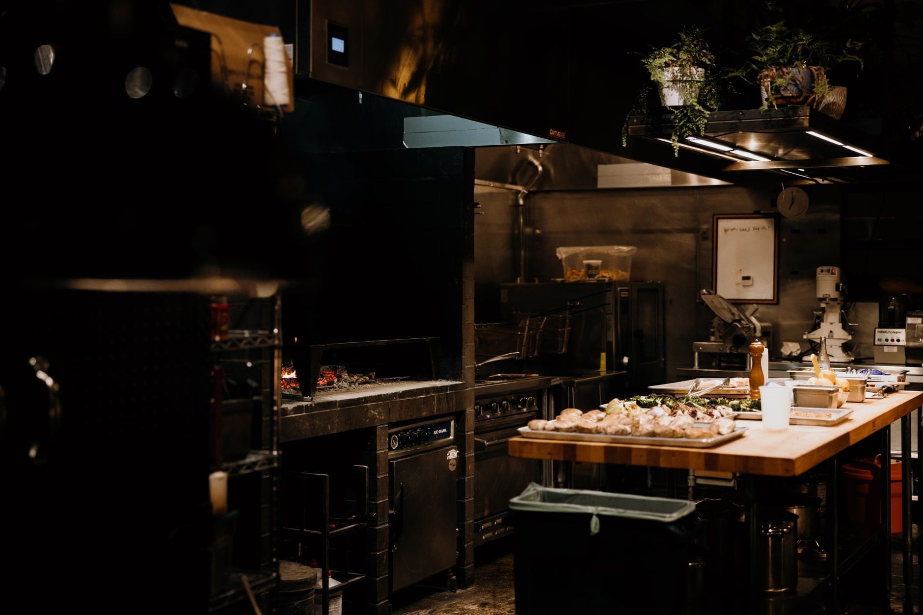 A warm, inviting view of a professional restaurant kitchen with ingredients ready for cooking.